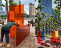 Two people with their hands touching each others through coloured glass