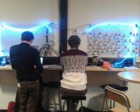 Tarim's prototype of interactive light strips, draped around Ben and Josh as they work