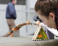 Image of One Five West's work: a woman playing with an interactive artwork.