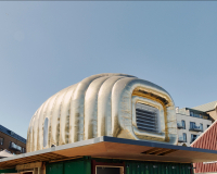 An image of the golden Martian house, set up on a platform the M Shed Square