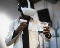 A man in a white shirt tests a set up with a VR headset and biometric scanner.