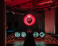A CGI image of a floating red face in an exhibition space. The surrounding room is dark and shadowy.