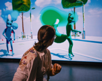 An attendee of the I Am Your Mirror workshop, shot from the front, turns around to look at an image of 3d rendered animals.