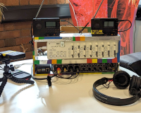 An image of a modified Korg DJ controller on a table with some headphones, dictaphones and other musical paraphernalia. 