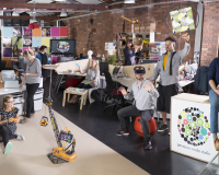 Pervasive Media Studio with studio residents and staff holding up projects