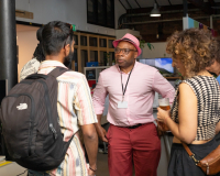 A group of people standing around chatting in the Pervasive Media Studio.