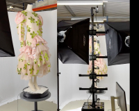 An image in three parts - in the left image, a mannequin with a dress on, stood on a pedestal; the dress is a sheer adjacent material, is shell pink in colour, and has green flowers dotted all over it. In the middle, the mannequin sits at the centre of a photography studio, with digital photography equipment surrounding it, to capture a render, shown in the image on the far right. 