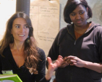 An image of Pilar Santelices, to the left of the frame, mid workshop with a participant to her right. 