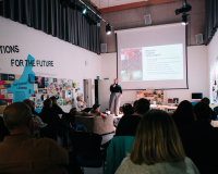 An image of Coral Manton giving a talk on the role of the Creative Technologist to a large audience. 