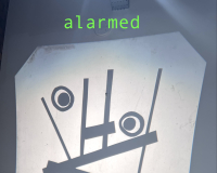 Projected abstract face with geometric shapes and circles conveys alarmed emotion. The word "alarmed" is displayed above in green text.