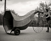 An image of Dominique Vyborna pushing a comically oversized horn on wheels.