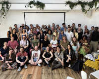 A group of people stand smiling and facing the camera