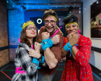 Three people stand in the Studio, posing in costume as part of a game