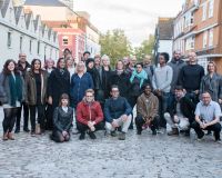 A group of around 20 standing looking at the camera who are the network's Immersion Fellos