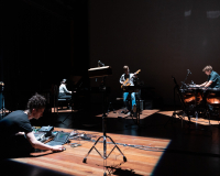 Image of a music ensemble improvising in a theatre space.