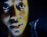 large face projection and live performance production photo from 'Dark Land Light House'