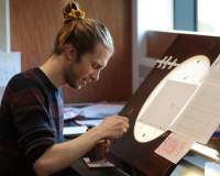 William working over a light table.