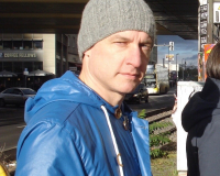 Picture of Ade Armstrong wearing a blue duffle coat and grey beanie on a street in Berlin