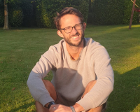 Ben, a white male with glasses, sat in the sun