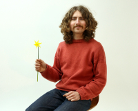 cool dude sitting on chair holding yellow flower