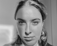 B&W headshot of young woman with a bob and hoop earrings