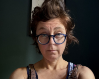 Woman with short brown hair and blue glasses