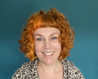 White woman in her 40's with curly orange hair