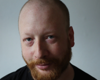 Picture of Tim X Atack, a white man in his 50s with a red beard and bald head