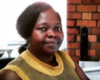 Image of a Black woman smiling at the camera