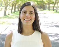 A woman standing in a sunlit park