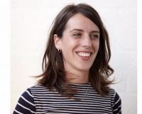 White female, with mid length brown hair and wearing a stripy top.