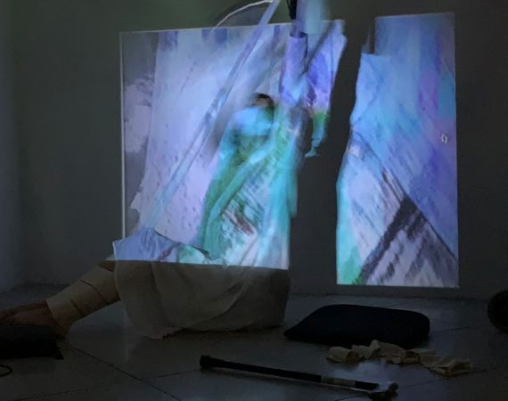 Image of a figure in front of a projection, wearing MiMu Gloves