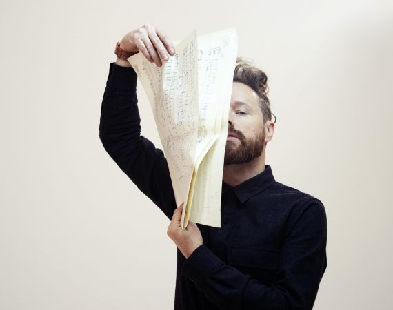 Charlie Williams (Larkhall) holds a handwritten score in front of his face.