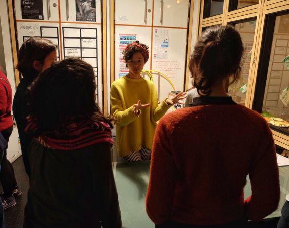 Lily Green, No Bindings director, talks to three people.