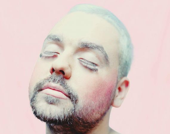 Nik Rawlings portrait with drag make up and pink background