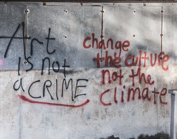 Graffiti that reads: Art is not a crime. Change the Culture not the Climate.