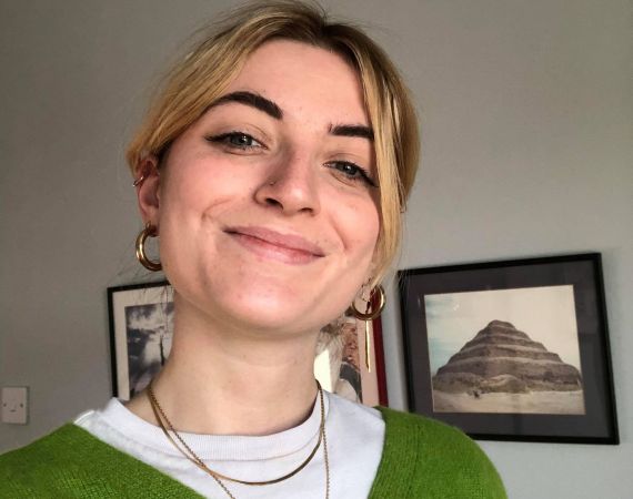 Zoe smiling in a green cardigan.