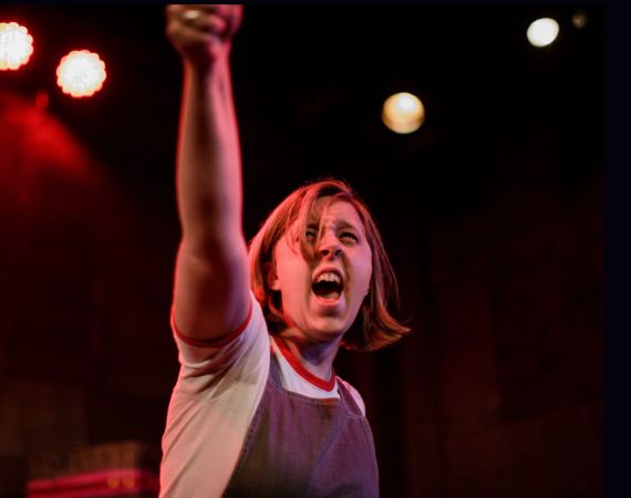 A person on stage with lights behind them 