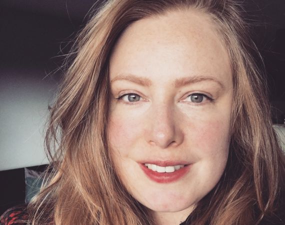 Photo of Danielle Rose, a white woman in her late thirties, strawberry blonde hair, blue grey eyes, smiling face