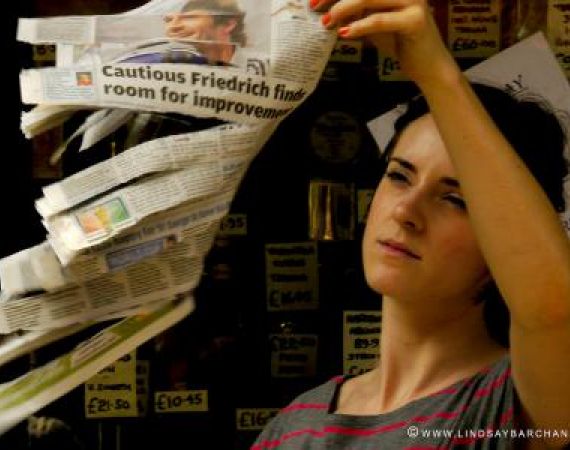 Dancer holding newspaper aloft