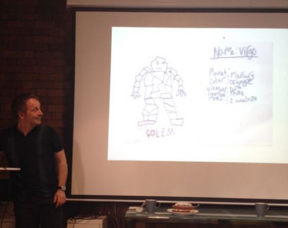 Seth showing us his son's drawing of one of his characters, a golem called Virgo, whose motto is 'I analyze'