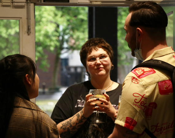 Photo of three people engaged in conversation