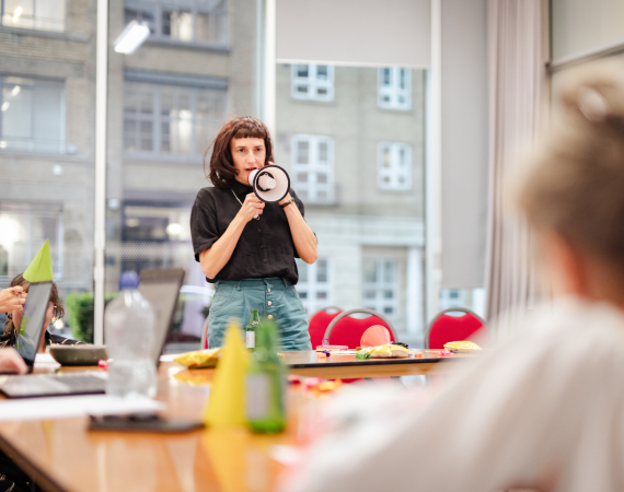 Photo of Rachael Clerke holding a megaphone in an office