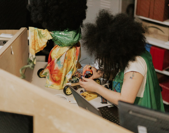 Image of artist Shrouk El-Attar building a robot at the Pervasive Media Studio.