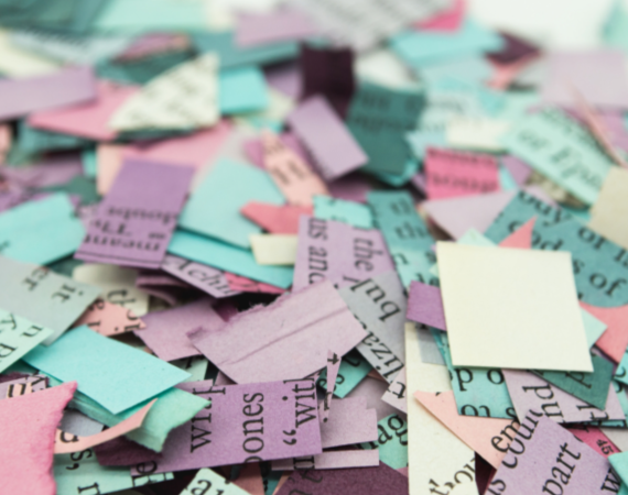 A random assortment of multi coloured paper squares with random letters printed on them, in a big pile. 