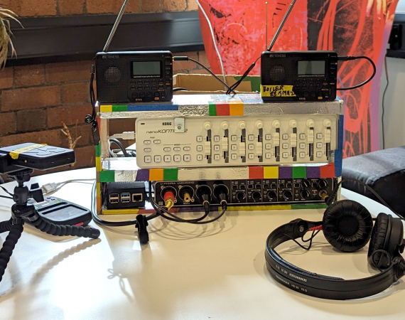 An image of a modified Korg DJ controller on a table with some headphones, dictaphones and other musical paraphernalia.