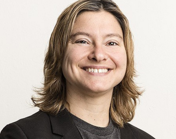 An image of Dr. Melanie Rieback - she is a blonde haired white woman, smiling broadly, in an official headshot, her head backgrounded completely in white.  