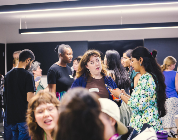 Image of group of people standing and chatting.