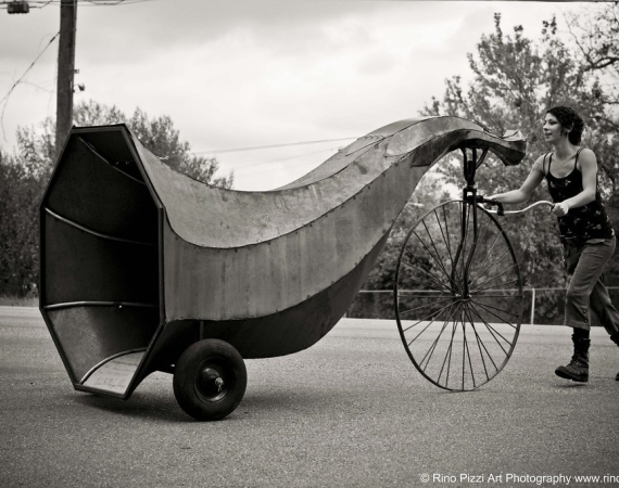 An image of Dominique Vyborna pushing a comically oversized horn on wheels.