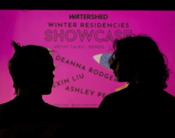 Image of two people in front of a projection